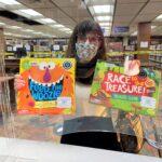 Barbara Bunting holds up two board games she just checked out from the library.