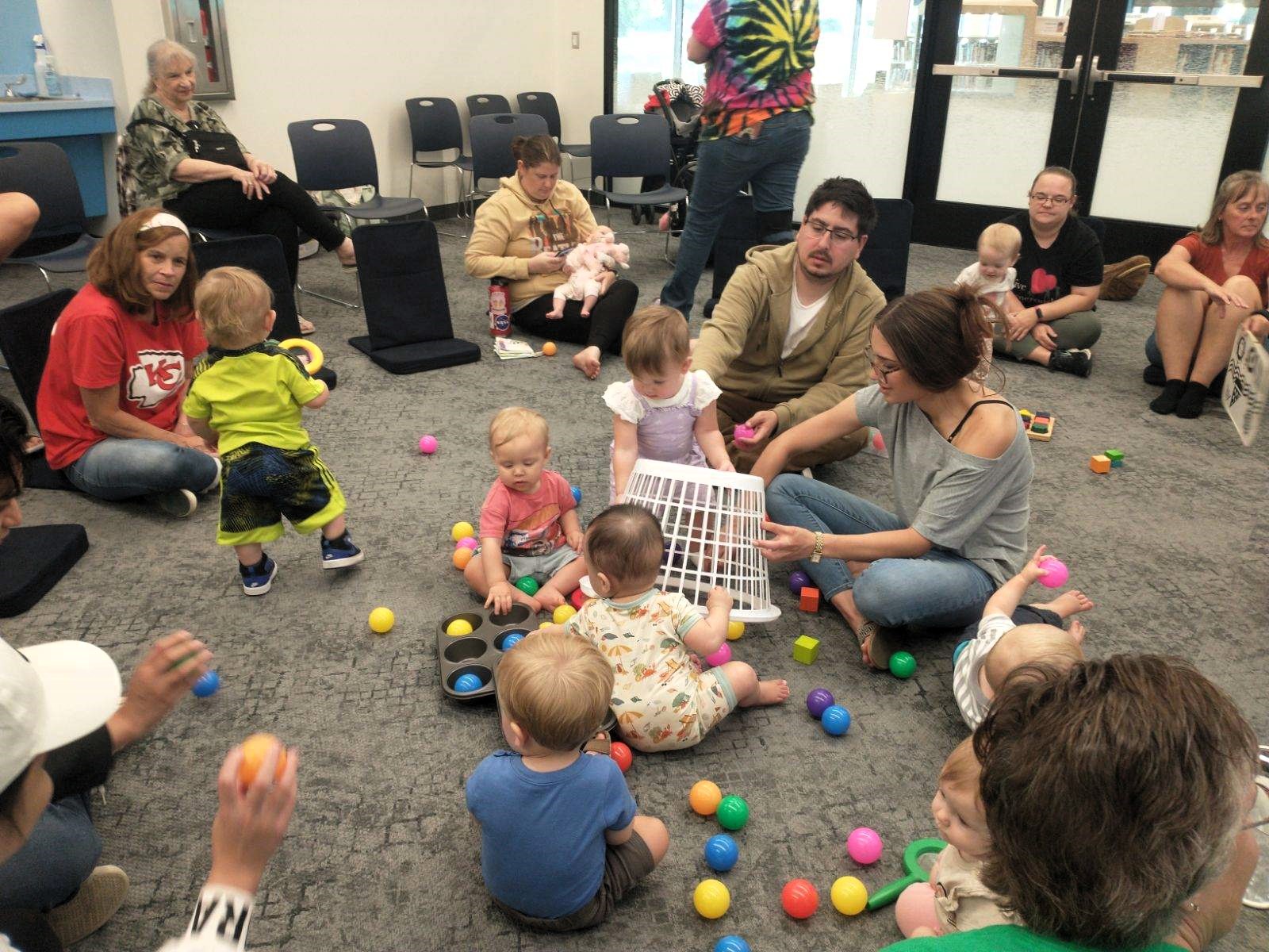 Parents and babies have fun with small plastic balls during a Baby StoryTime session.