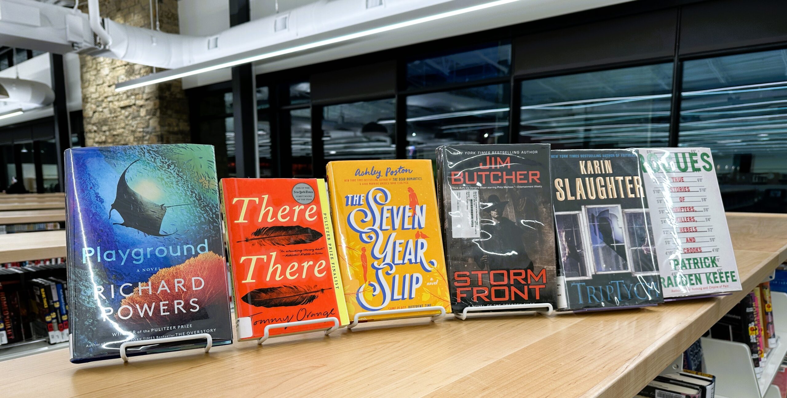 Copies of the March 2025 library book club selections are displayed atop a low shelf in the library.